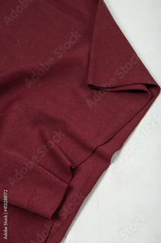 Pleats on fabric, knitted material of burgundy color, folds, knitted