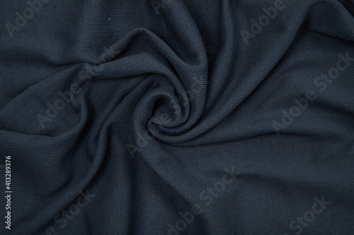 Pleats on fabric, knitted material of dark gray color, folds