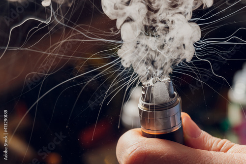 Splash glicerine on vape spiral. Big clouds of fog with visible tracers. Vape culture and no smoking. photo