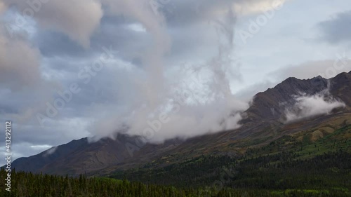 Time Lapse. Beautiful View of Canadian Nature with Mountains in the Background. Cloudy Sunset. Kathleen Lake, Kluane National Park, Yukon, Canada. Pan Right Slow Motion photo