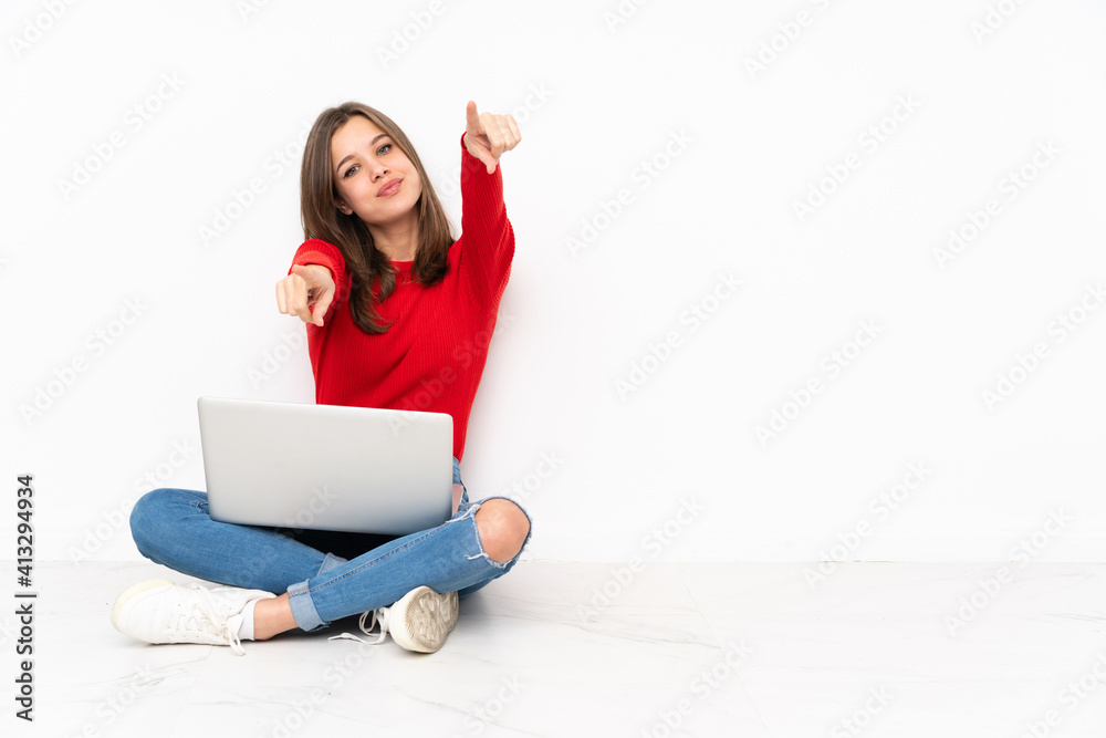 Tenaager girl working with pc isolated on white background points finger at you while smiling Tenaager girl working with pc isolated on white background points finger at you while smiling