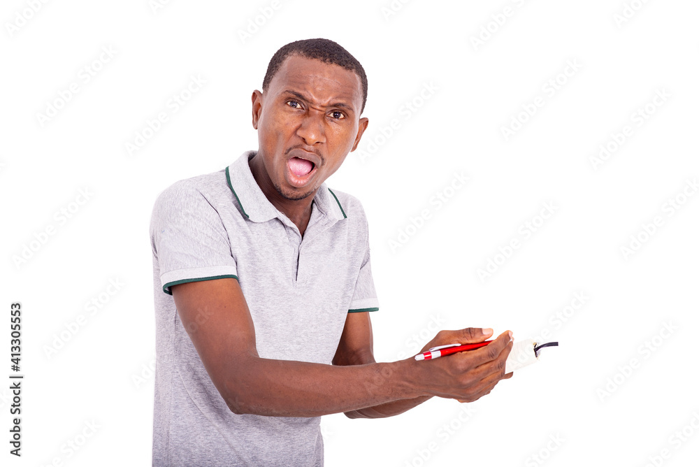 young angry man holding a notebook with a pen in hand. young angry man holding a notebook with a pen in hand.
