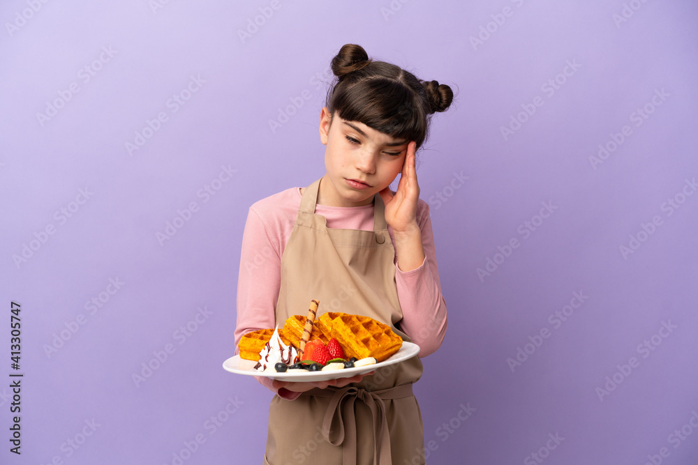 Little caucasian girl holding waffles isolated on purple background with headache Little caucasian girl holding waffles isolated on purple background with headache