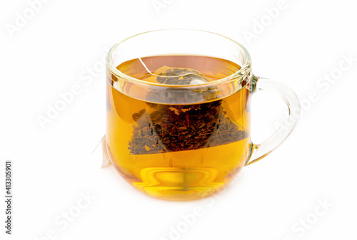 The process of dipping a bag of tea in a glass cup on a white background