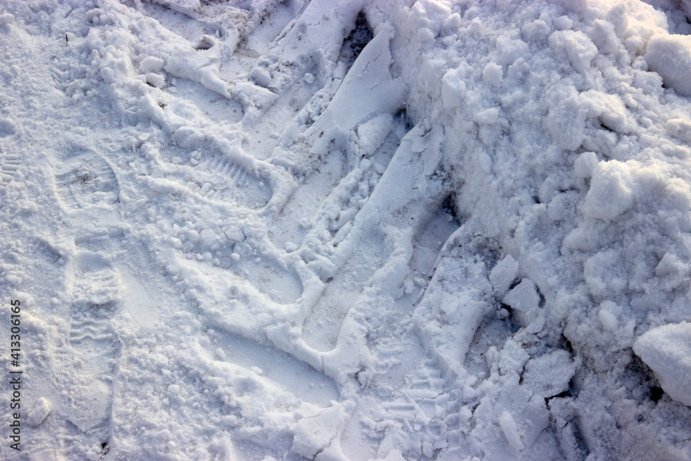 footprints and tractor tires track in the snow footprints and tractor tires track in the snow