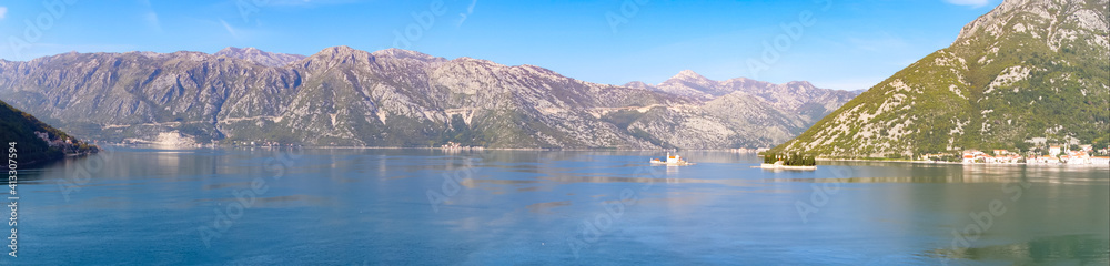 Panoramic view of Kotor bay surrounded by mountains with the city of Perast and the island of Our Lady of the rocks.