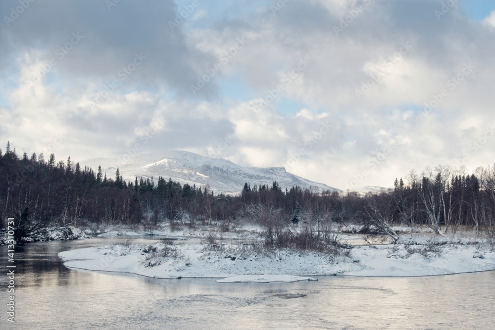 A winter view of the Vålån River and the hill in Vålådalen in northern Sweden