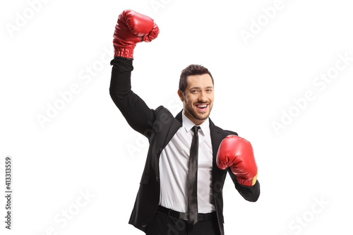 Businessman with boxing gloves raising one hand as a winner