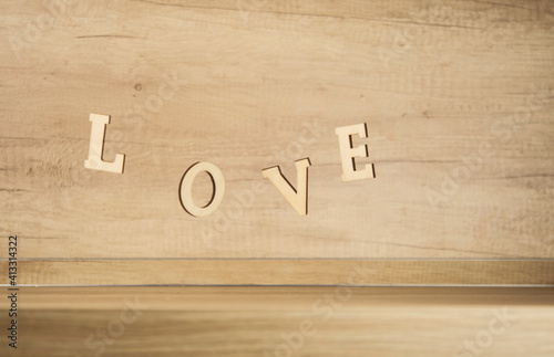 Flying in the form of word love on a wooden background. Happy Valentines Day