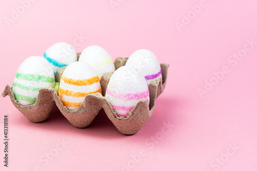 Colorful Easter eggs on a pink background. Copy space. Celebrating Easter