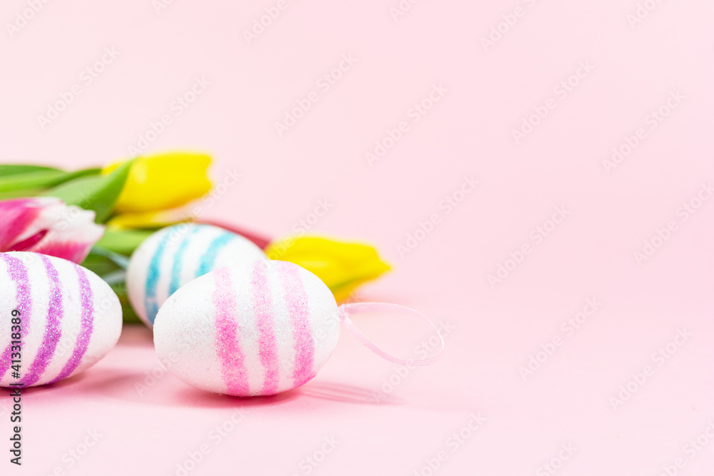Easter painted eggs with tulips on a pink background. Copy space. Easter celebration concept. Easter painted eggs with tulips on a pink background. Copy space. Easter celebration concept.