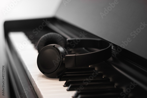 headphones on piano keys on black background