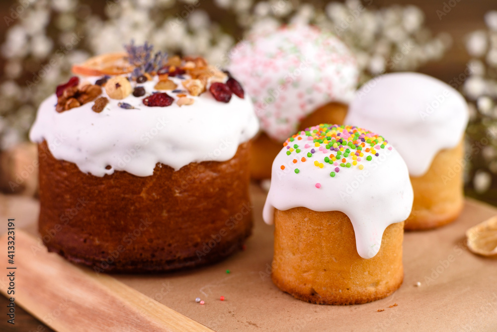 Festive cakes with white glaze, nuts and raisins with Easter eggs on the festive table Festive cakes with white glaze, nuts and raisins with Easter eggs on the festive table