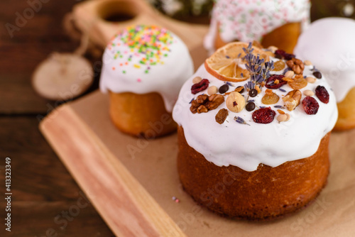 Festive cakes with white glaze, nuts and raisins with Easter eggs on the festive table
