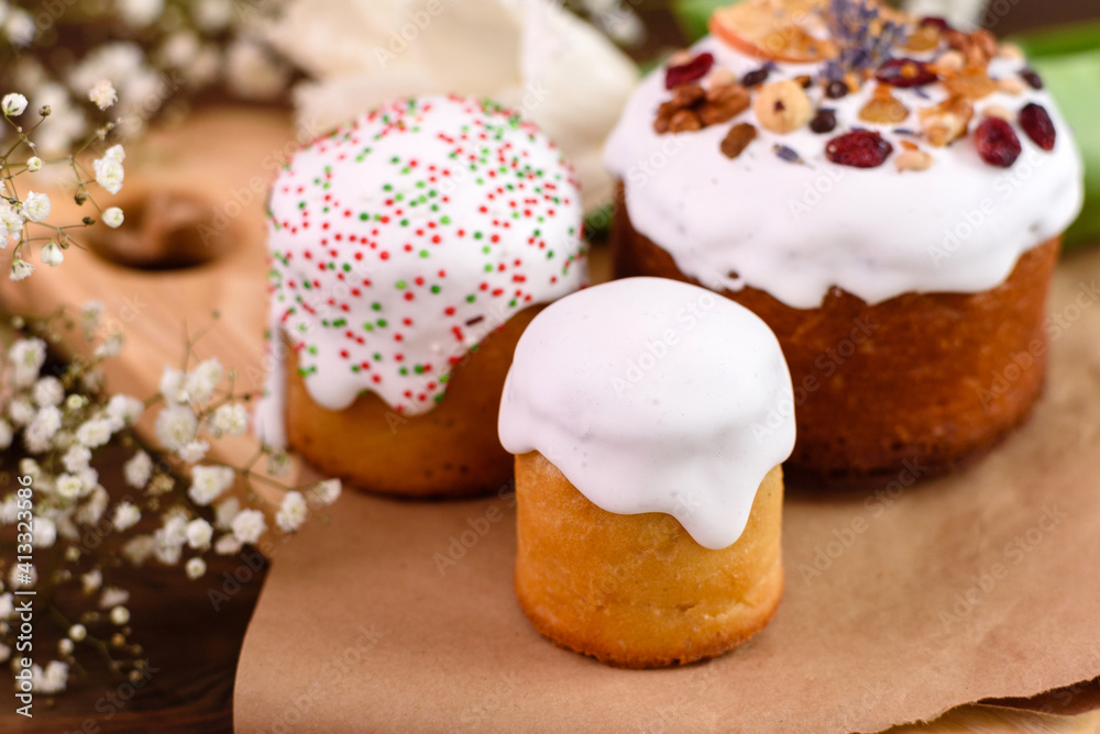 Festive cakes with white glaze, nuts and raisins with Easter eggs on the festive table Festive cakes with white glaze, nuts and raisins with Easter eggs on the festive table