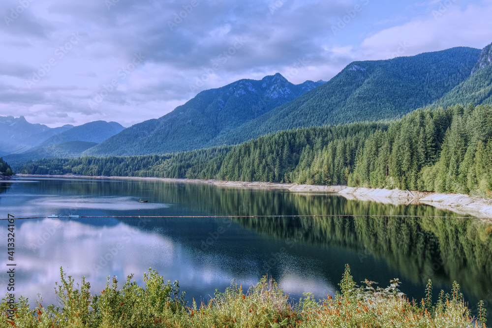 A scenic View of Cleveland Dam reservoir surrounded by mountains at sunset, North Vancouver, Canada