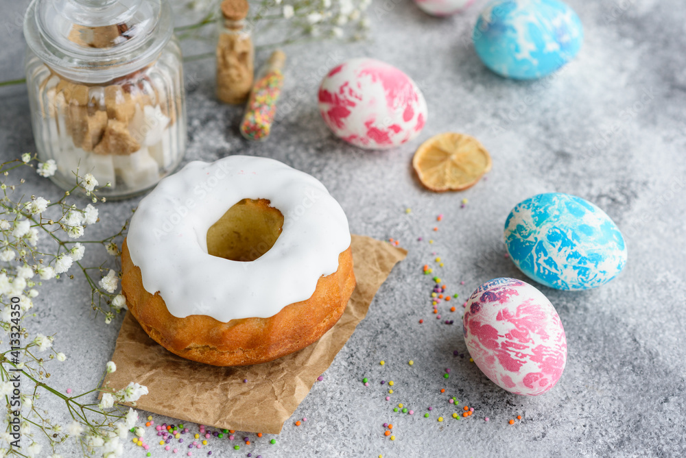 Festive cakes with white glaze, nuts and raisins with Easter eggs on the festive table Festive cakes with white glaze, nuts and raisins with Easter eggs on the festive table
