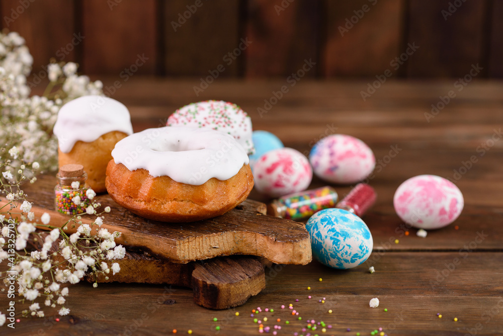 Festive cakes with white glaze, nuts and raisins with Easter eggs on the festive table Festive cakes with white glaze, nuts and raisins with Easter eggs on the festive table