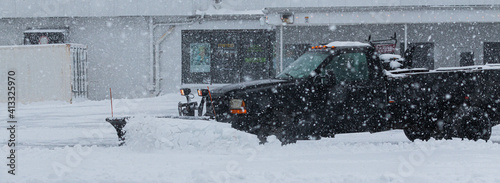 Canvas Print Private contractor plowing parking lot during a blizzard