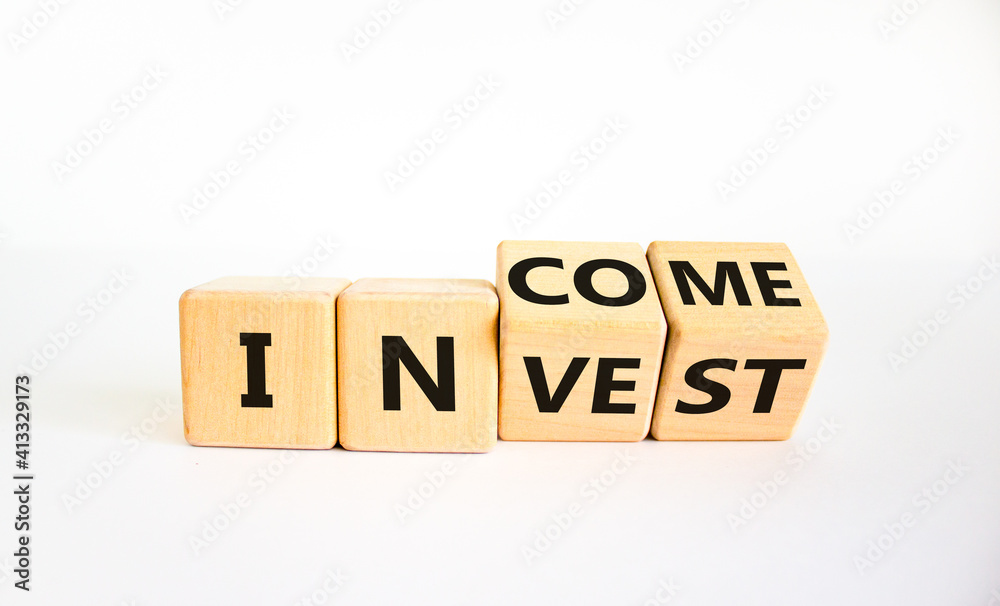 Invest or income symbol. Turned wooden cubes and changed the word 'invest' to 'income'. Beautiful white background, copy space. Business and invest or income concept. Invest or income symbol. Turned wooden cubes and changed the word 'invest' to 'income'. Beautiful white background, copy space. Business and invest or income concept.