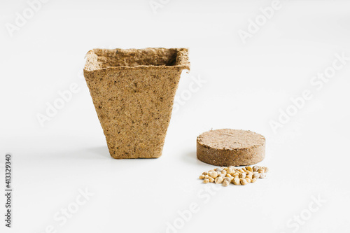 pot and tablet with earth and soil. Gardening at home. Growing food on windowsill. step by step spring planting plant seeds in a pot on a white background. step two
