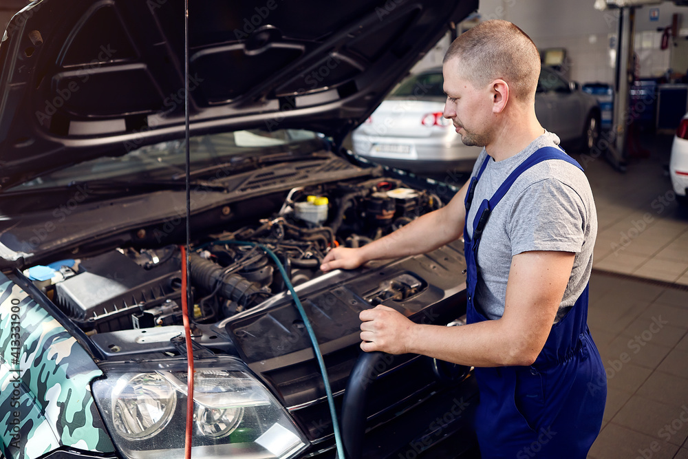 Mechanic checks air conditioning system in car auto service Mechanic checks air conditioning system in car auto service