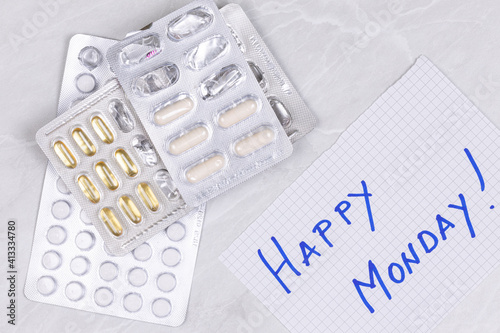Pile of Medics and Pills with Happy monday sign on the paper.