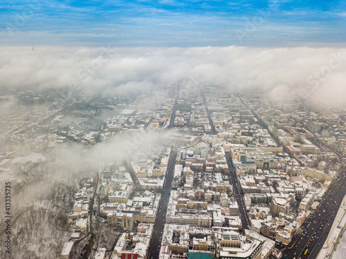 Fog over the snowy Kiev city. Aerial drone view. Foggy winter day.