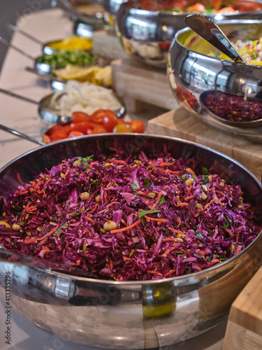 Red cabbage and lettuce salad with carrot served in a buffet of metal bowls 