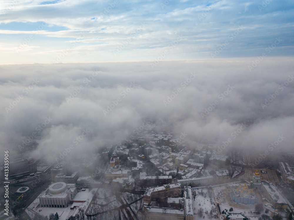 Fog over the snowy Kiev city. Aerial drone view. Foggy winter day.