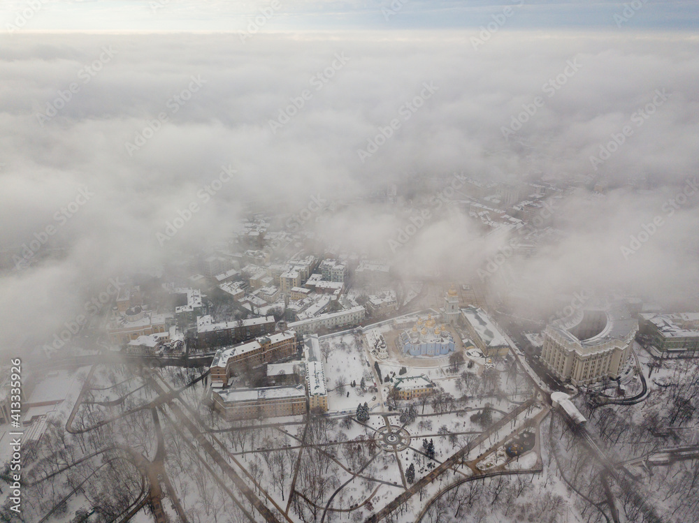 Fototapeta premium Fog over the snow-covered St. Michael's Cathedral in Kiev. Aerial drone view. Foggy winter day.