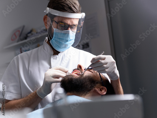 Dentist performs a regular examination of the patient
