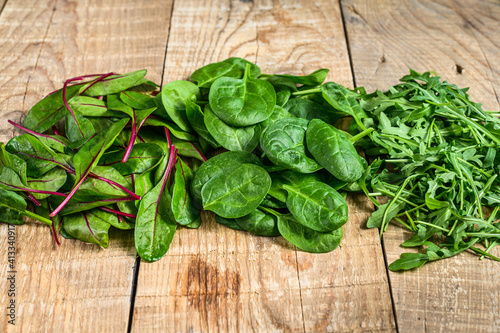 Mix Salad leafs, Arugula, Spinach and swiis Chard. Wooden background. Top view