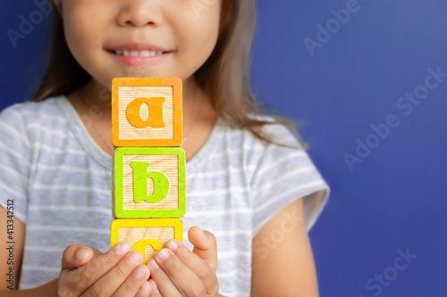 A happy little kid learning abc with blocks. Children learning.