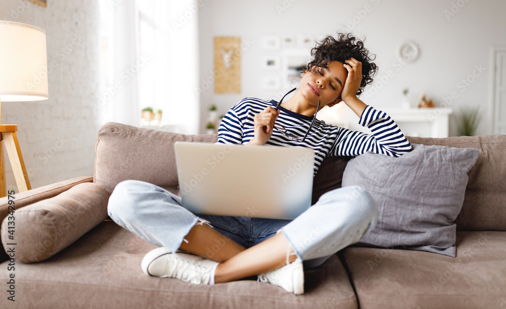 tired ethnic freelancer working on project at home