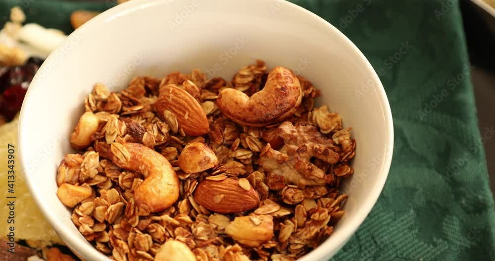 Healthy homemade granola with assorted nuts and dried fruits rotating