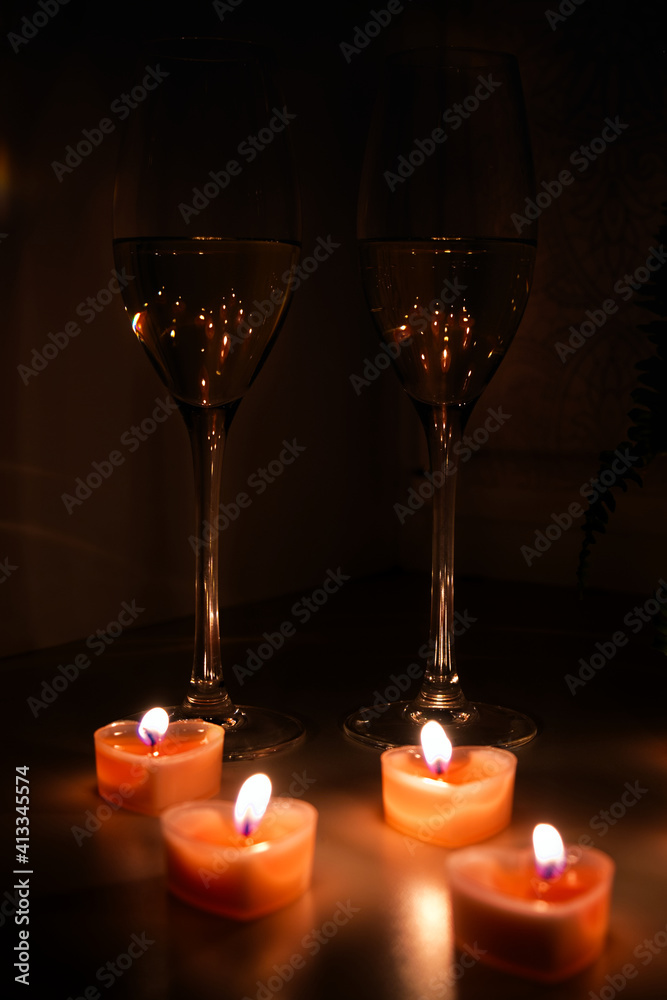 Two glasses of white wine with small red candles in night time. Romantic and love rendezvous concept. Two glasses of white wine with small red candles in night time. Romantic and love rendezvous concept.