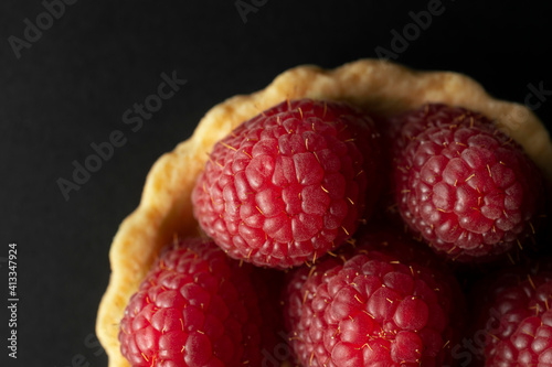 Raspberry tart, top view macro photography. Homemade raspberry tart on the black background.