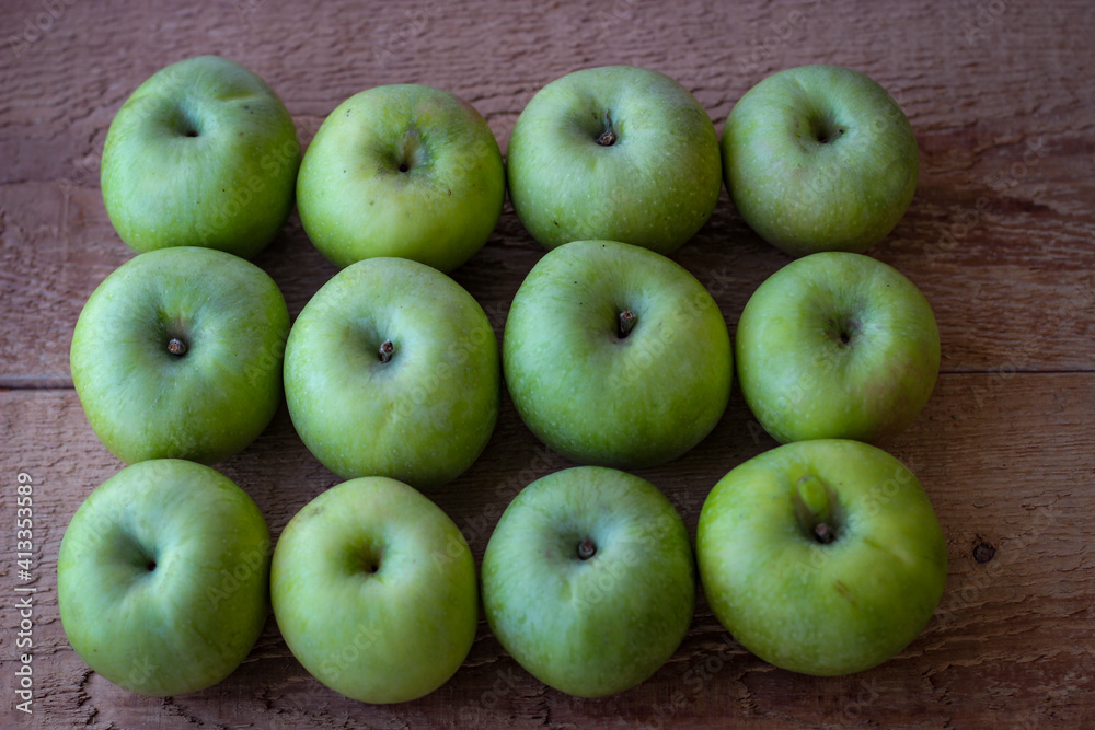 Green apples stand on a wooden surface Green apples stand on a wooden surface