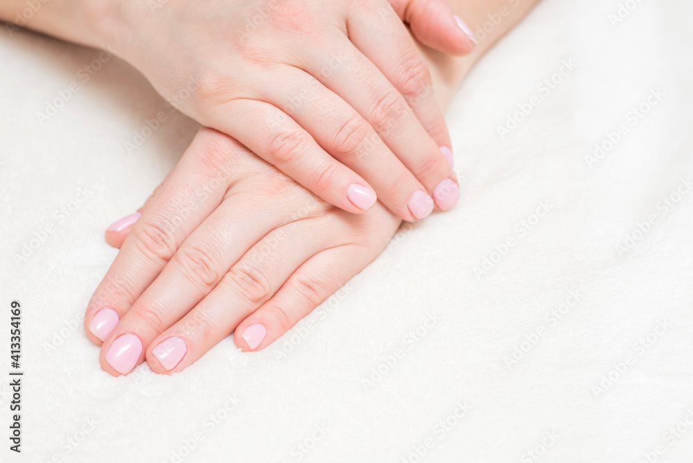 Closeup view of beautiful female hands on towel. Beautiful female hands  on towel. Hand care. Woman cares for the nails on hands. Beauty treatment with skin of hand