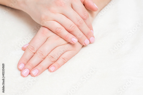 Closeup view of beautiful female hands on towel. Beautiful female hands  on towel. Hand care. Woman cares for the nails on hands. Beauty treatment with skin of hand