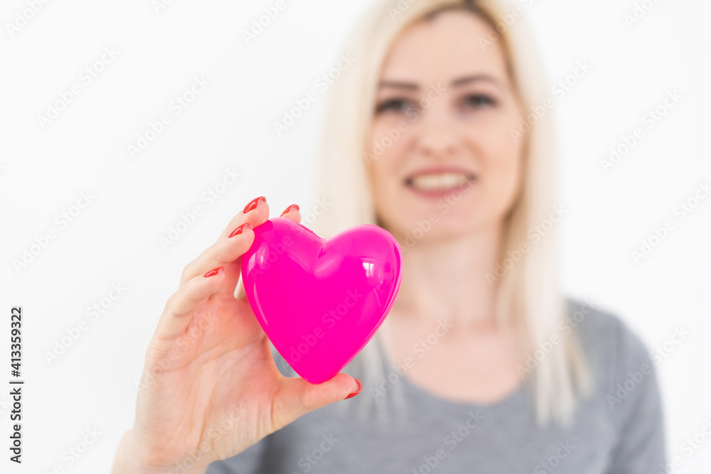 Valentine's Day. Beautiful smiling woman with a gift in the form of heart in his hands Valentine's Day. Beautiful smiling woman with a gift in the form of heart in his hands