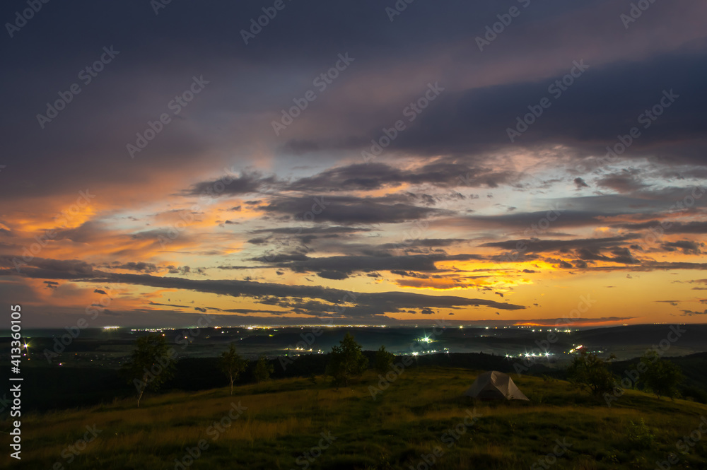 Tent on a hill against a background of sunrise in the carpathians