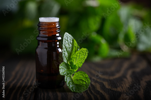 Blank amber bottle with essential oil Peppermint with  mint leaves