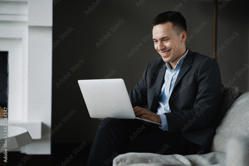 the manager prints a text message on the laptop computer. social network chat with partners. The economist is a man in a business suit sitting in a stylish modern office.