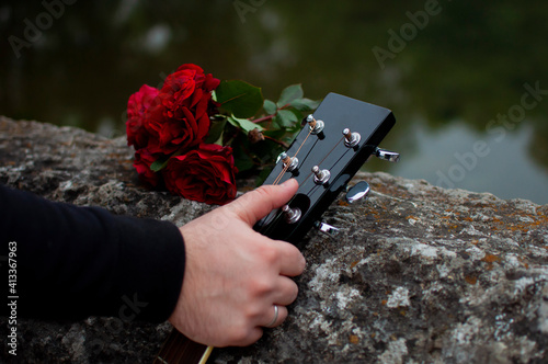 Man's hand holding guitar on the Roman Bridge