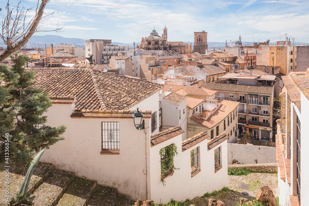 Old town view of terracotta rooftops and Granada Cathedral in the historic Moorish or Arab Quarter (albaicin) in Granada, Andalusia, Spain.