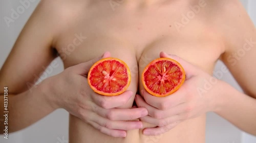 A slice of red blood orange covering my chest. Women's breasts. Breast health. Breast cancer