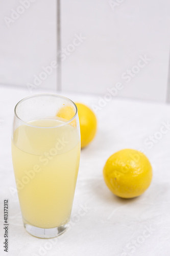Homemade Lemonade in the glass with lemons on the table