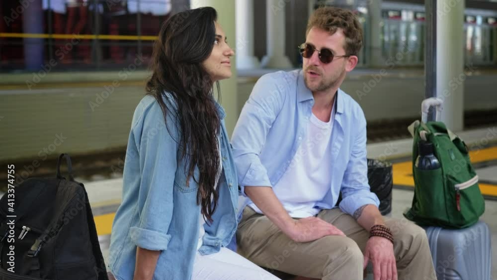 pair of travellers are sitting on railway station pair of travellers are sitting on railway station